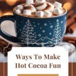 A close-up photo of a cup of hot cocoa with a marshmallow, cinnamon stick, and chocolate shavings on top.