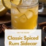 A classic spiced rum sidecar cocktail in a coupe glass with a lemon and cinnamon garnish.