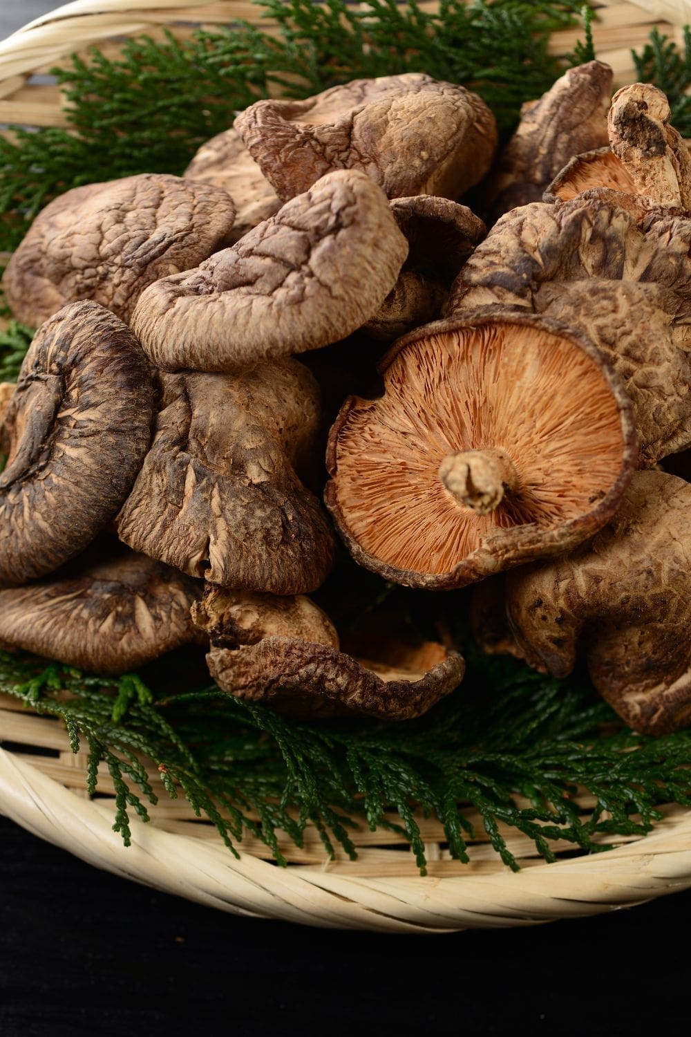 A close-up photo of savory shiitake mushroom tartlets arranged on a rectangular wooden cutting board. 