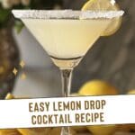 A martini glass with a lemon drop cocktail sits on a wooden table.