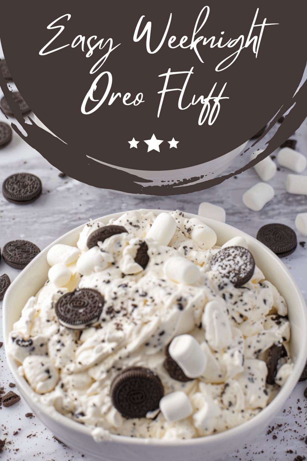 A close-up image of white bowl filled with Oreo Fluff dessert on a table.