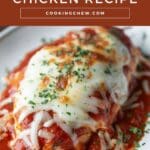 A white plate with a boneless, skinless chicken breast topped with melted mozzarella cheese and a red sauce.