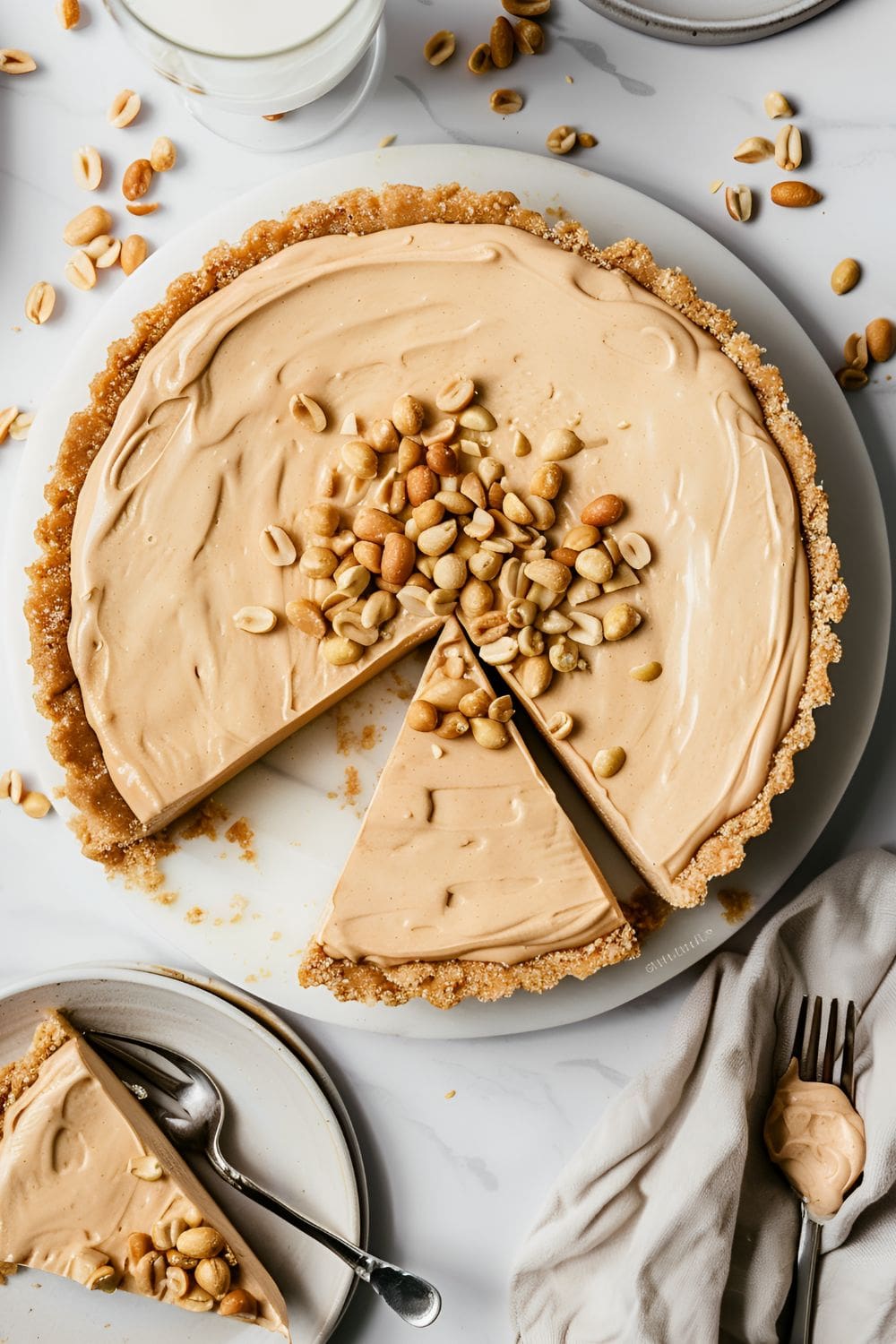 A rich and creamy no bake peanut butter pie with a graham cracker crust, and topped with chopped peanuts.