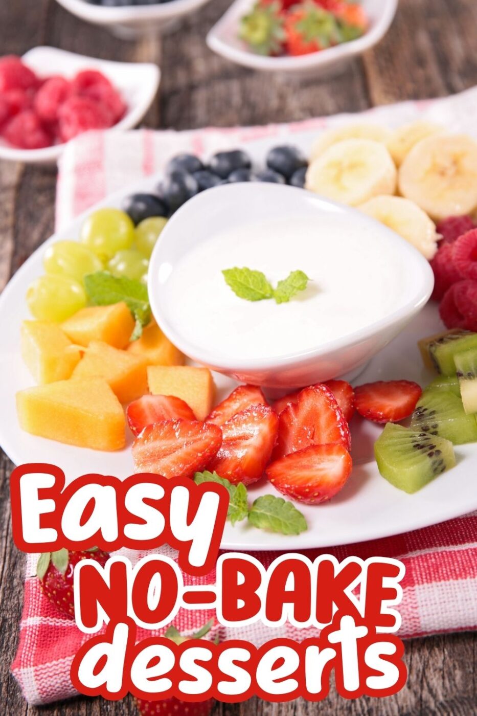 A shapely white bowl with sweet cream cheese dip surrounded by fruits like banana, kiwi, mango and blueberries