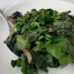 A bowl of vibrant sautéed mixed greens, ready to serve as a healthy side dish.