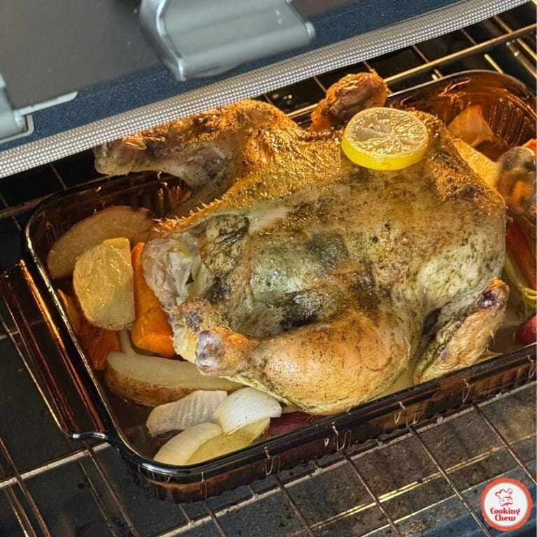 Oven-roasted whole chicken with vegetables, seasoned and golden.