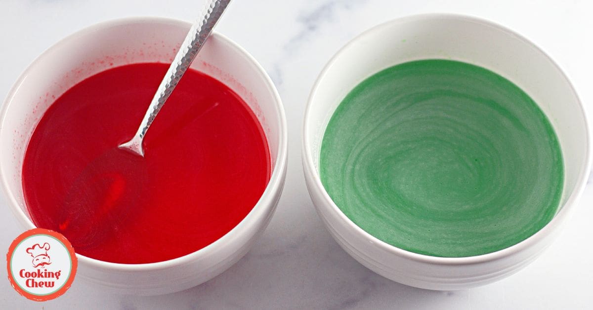 A close-up of strawberry lime Jello cake with a dollop of whipped cream on top.