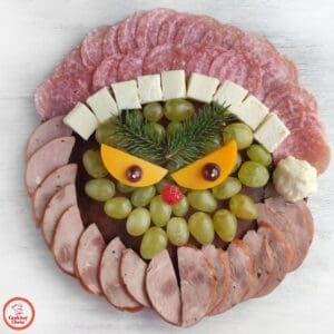 A festive Grinch-themed grazing board with Christmas snacks and treats.