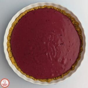 A vibrant cranberry tart with a glossy finish and unique cornflake crust.