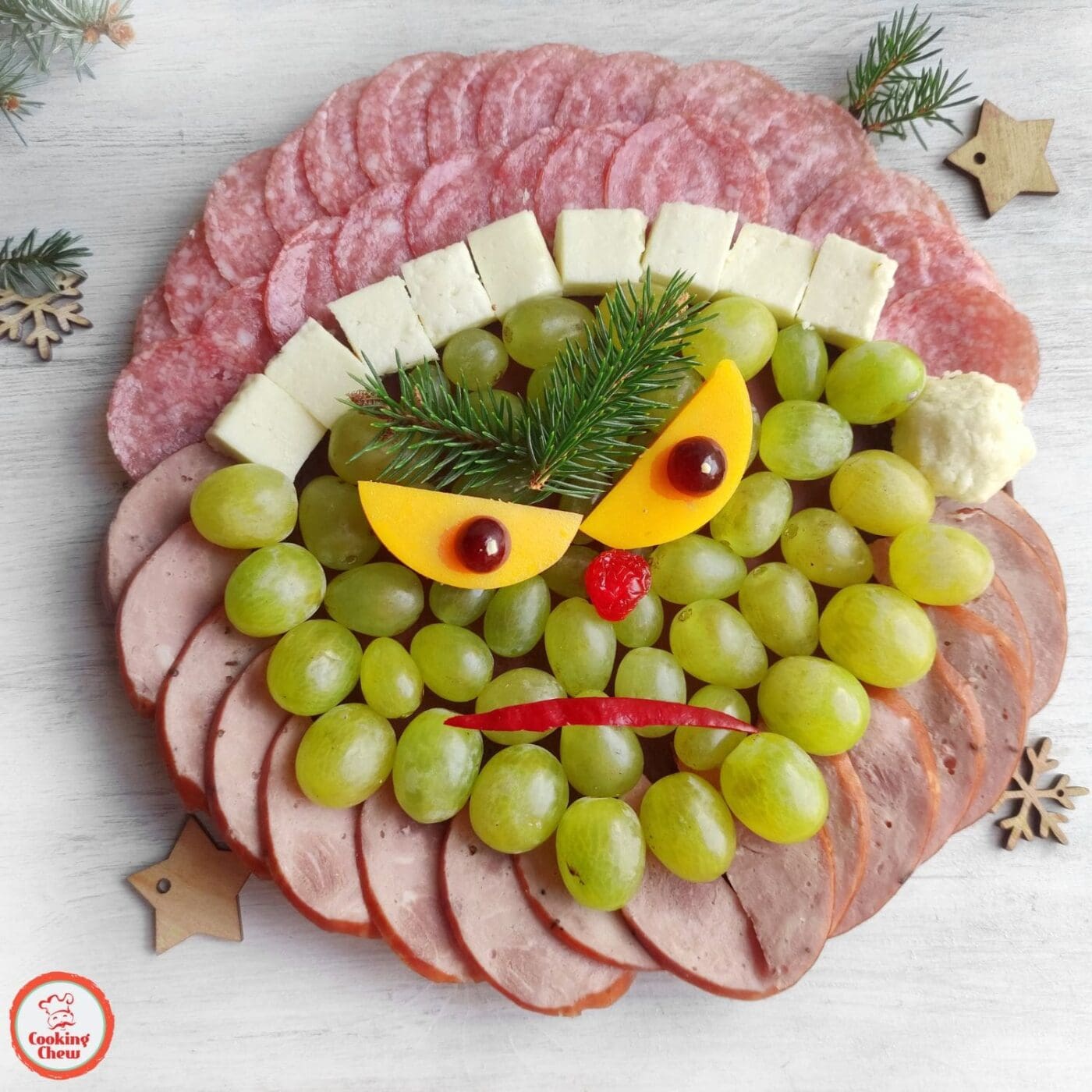 A holiday charcuterie board with Grinch-inspired snacks for Christmas parties.