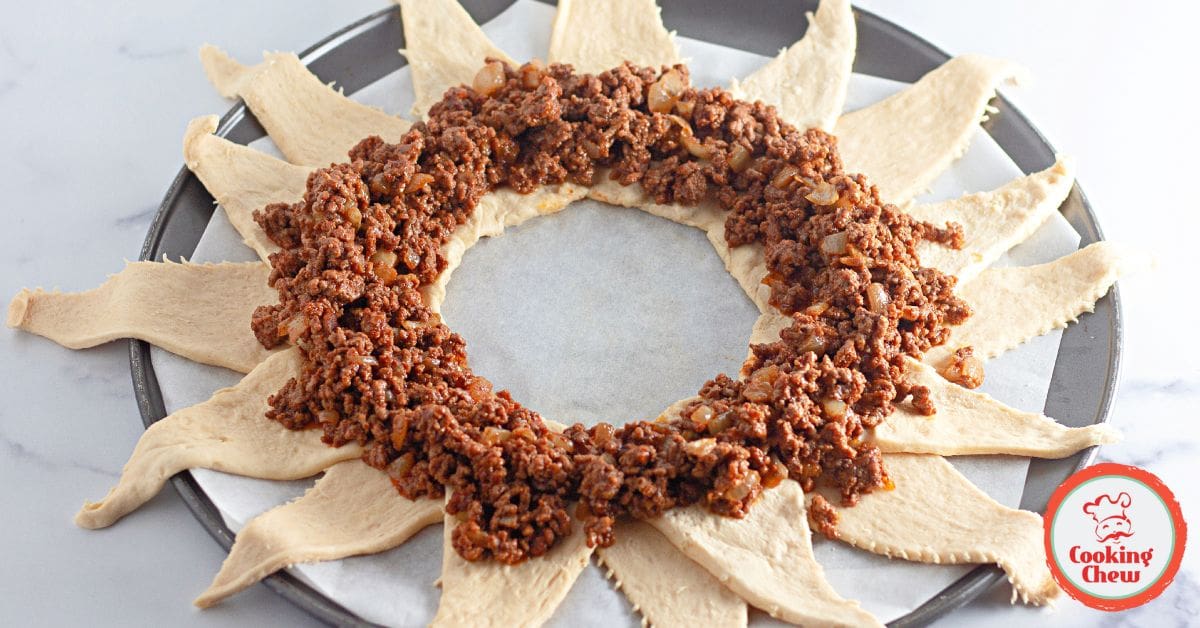 A perfectly baked taco crescent ring with cheese and garnishes.