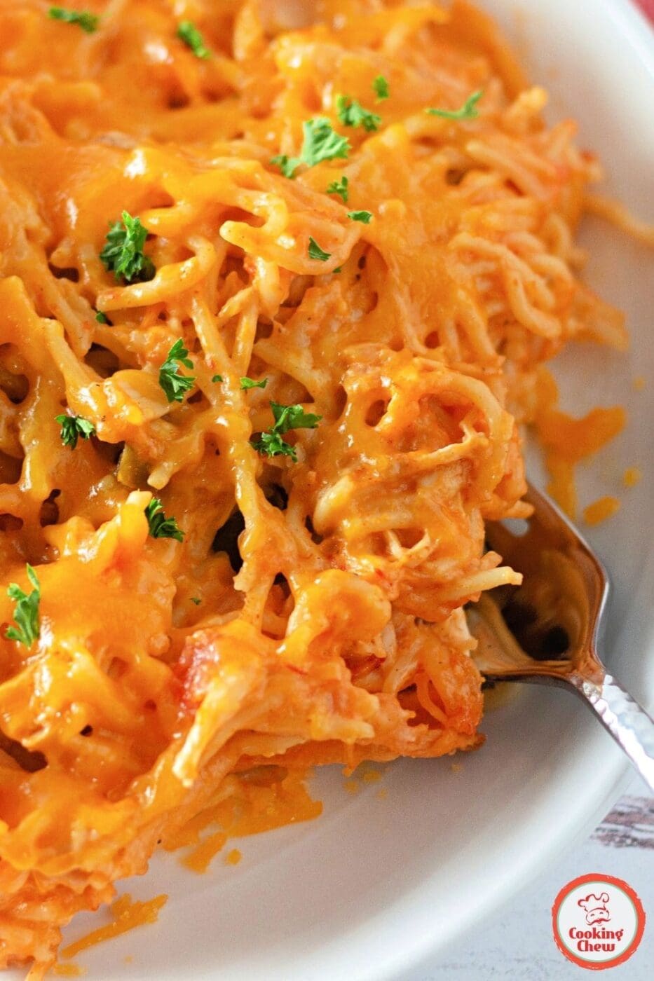 A creamy, cheesy chicken taco spaghetti casserole garnished with fresh cilantro and served in a baking dish.
