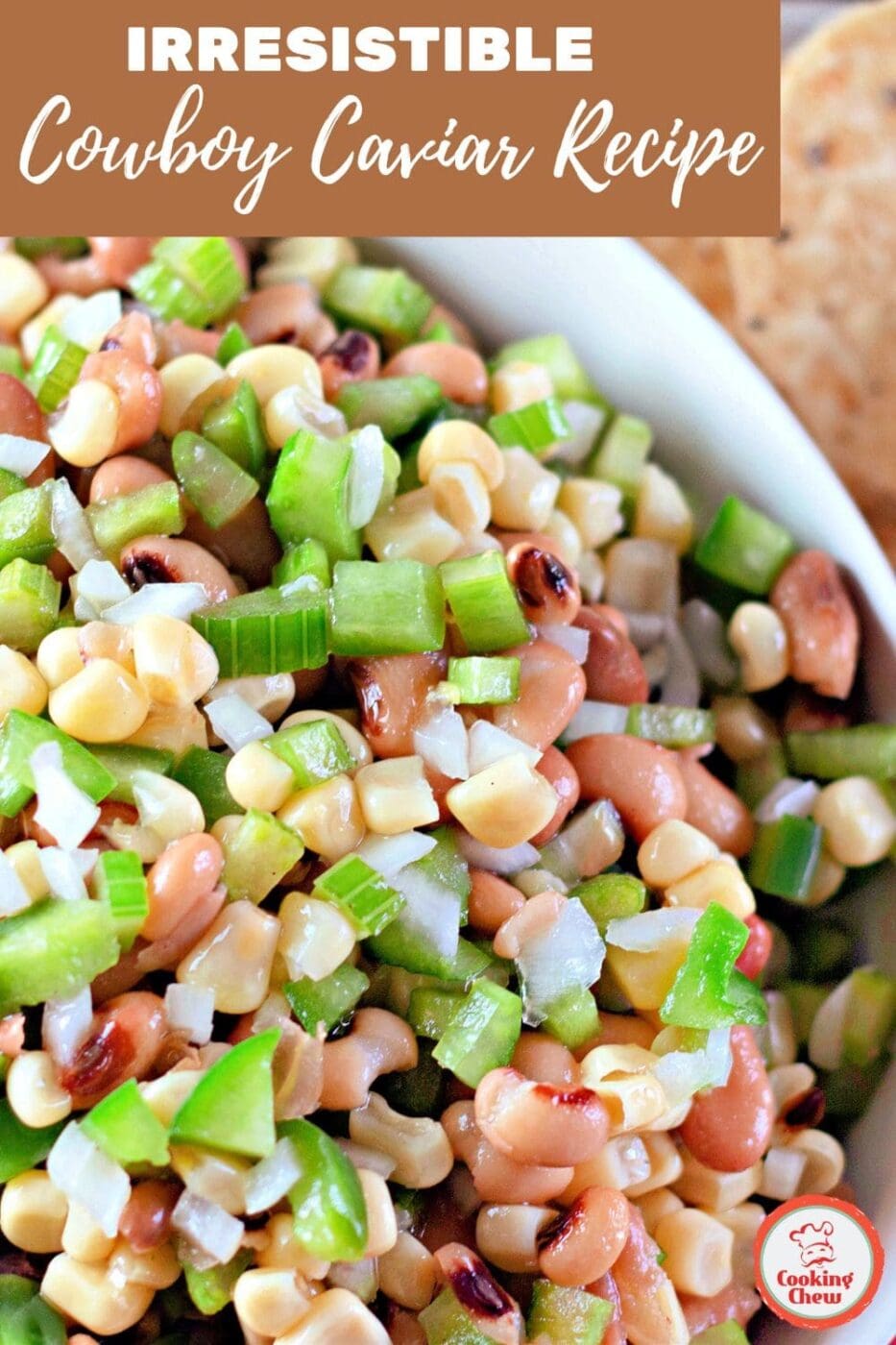 A colorful cowboy caviar dip with corn, beans, and fresh veggies served with chips for a party-ready appetizer.