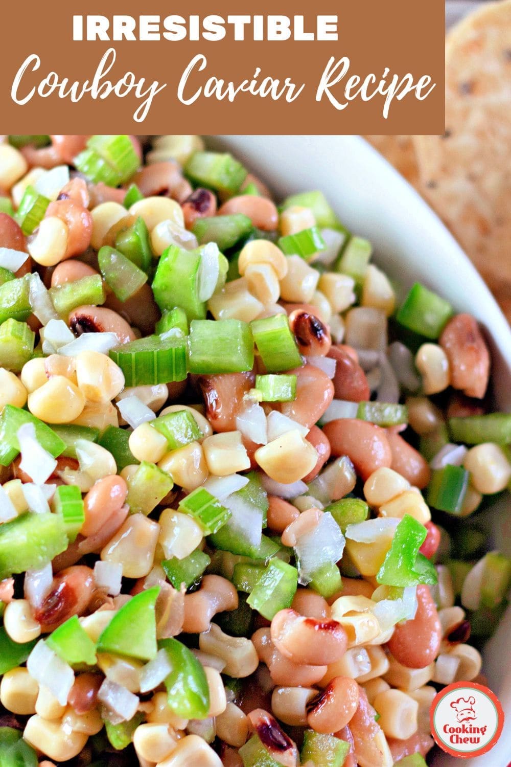 A colorful cowboy caviar dip with corn, beans, and fresh veggies served with chips for a party-ready appetizer.