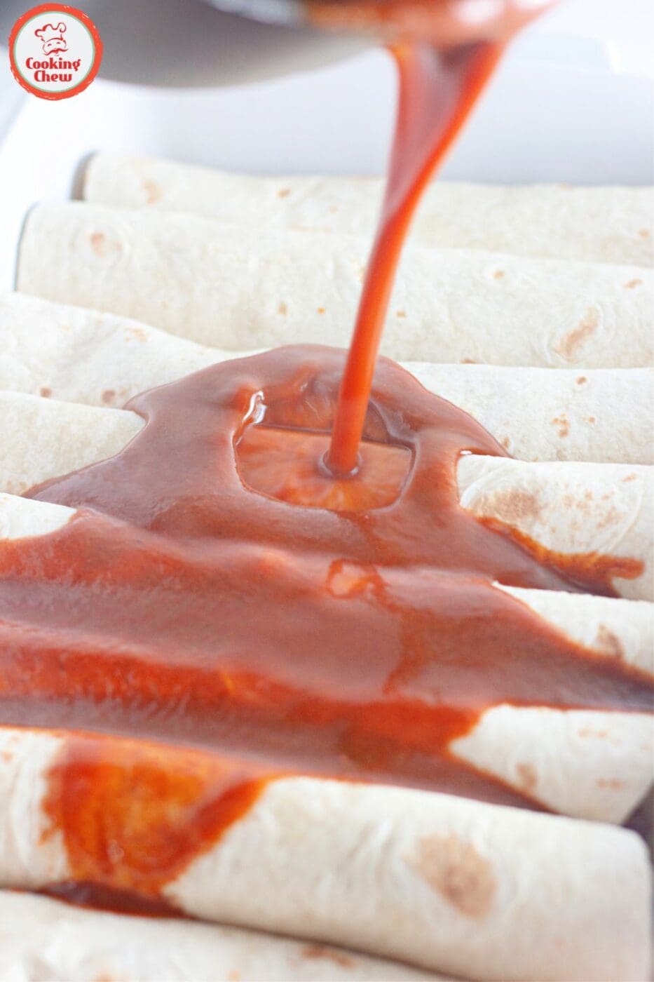 Cheesy beef enchiladas served with red sauce and fresh toppings.