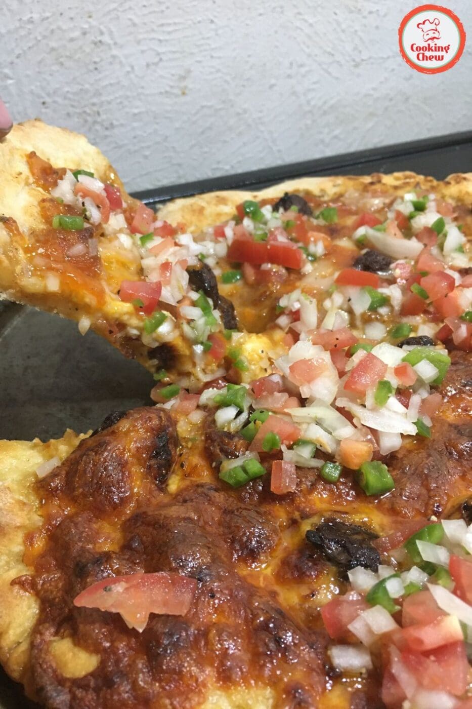 A freshly baked taco pizza topped with ground beef, cheese, lettuce, tomatoes, and sour cream on a golden homemade crust.