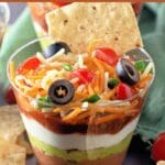 No-cook 7 layer dip cups served in clear cups with colorful layers.