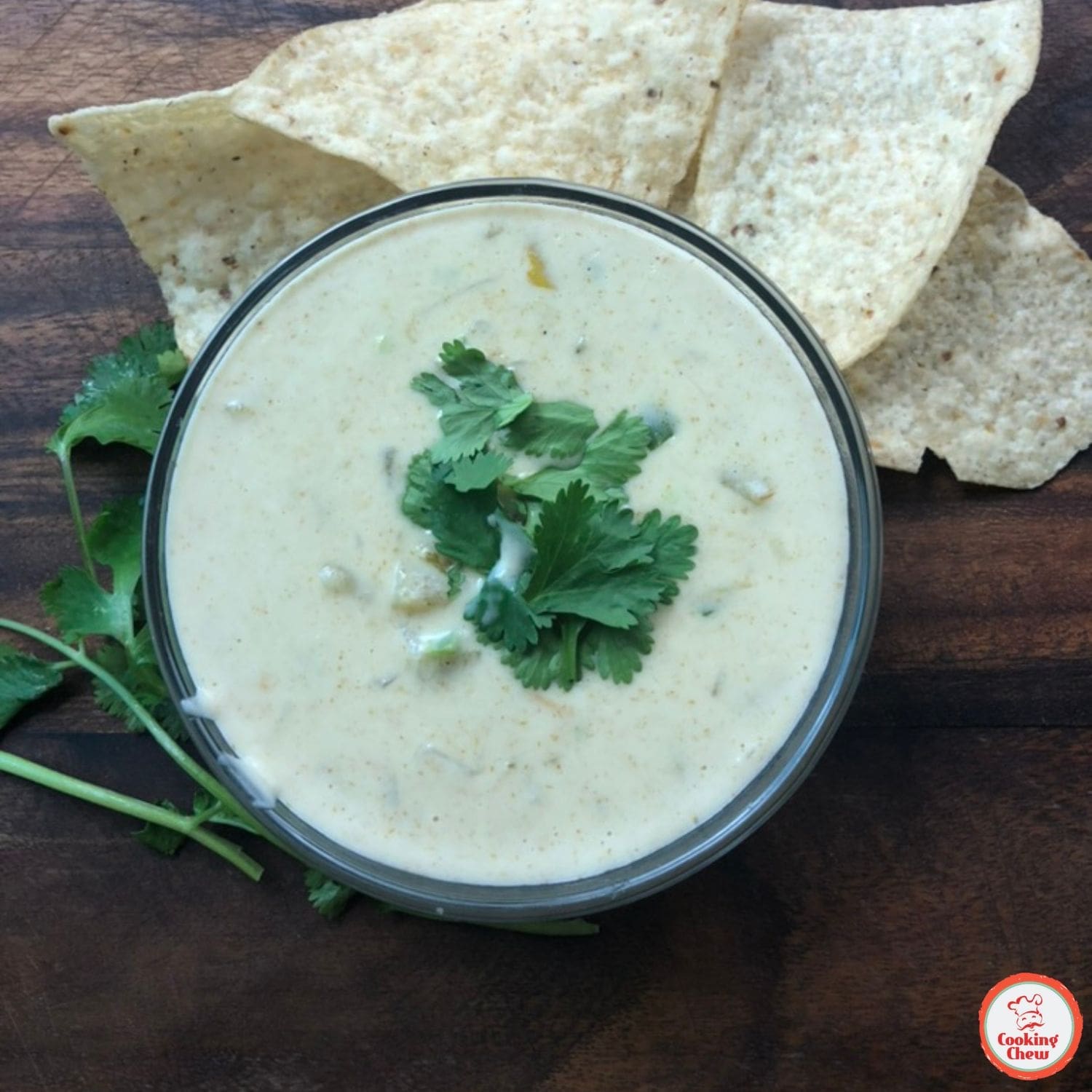 Queso dip with fresh cilantro and a side of tortilla chips.