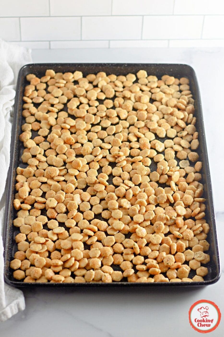 A baking tray filled with crispy ranch oyster crackers fresh out of the oven.