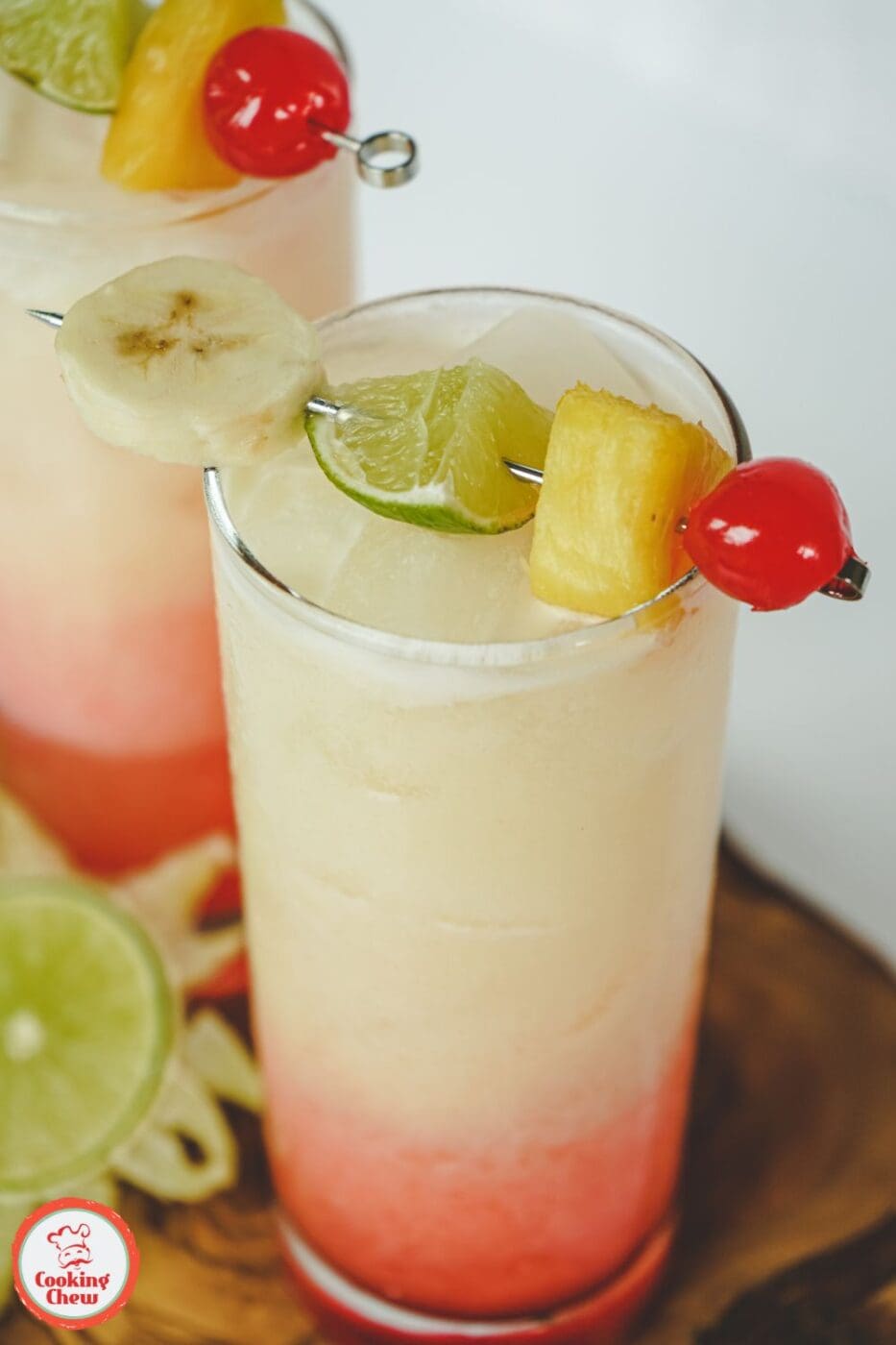 A tropical banana rum cocktail served in a glass, garnished with a banana slice and lime, with a refreshing golden hue.