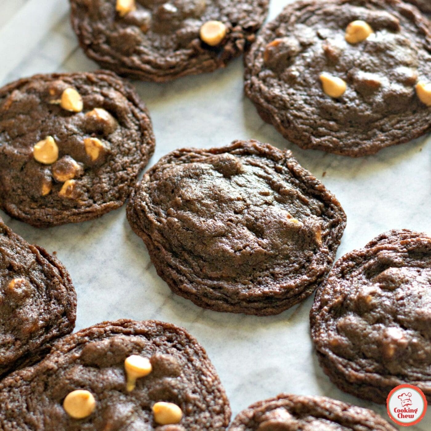 A plate of soft and chewy chocolate peanut butter chip cookies, with one cookie broken in half.