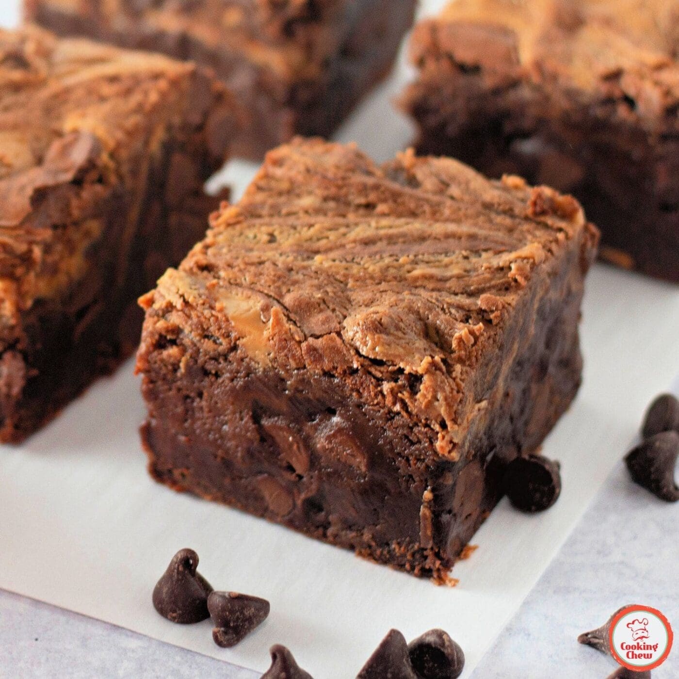 A stack of gooey peanut butter swirl brownies on a plate.