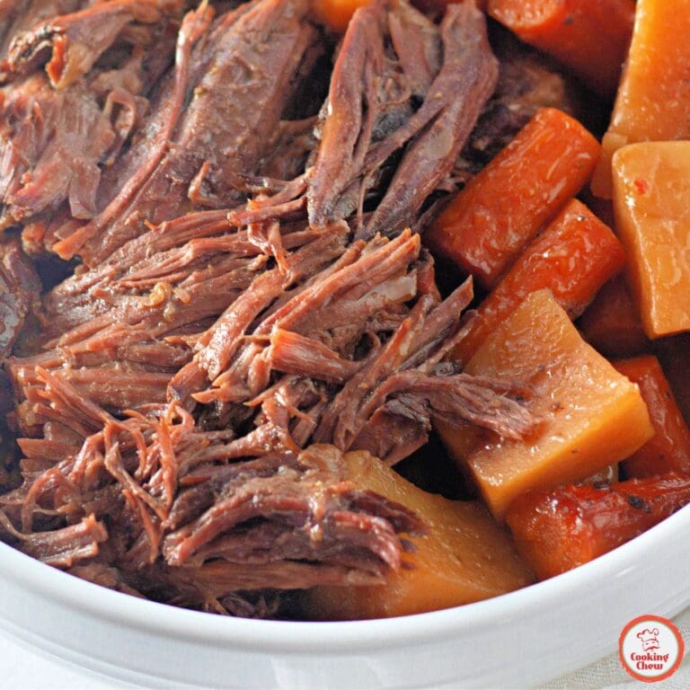 A plate of slow-cooked beef roast with vegetables and mashed potatoes.