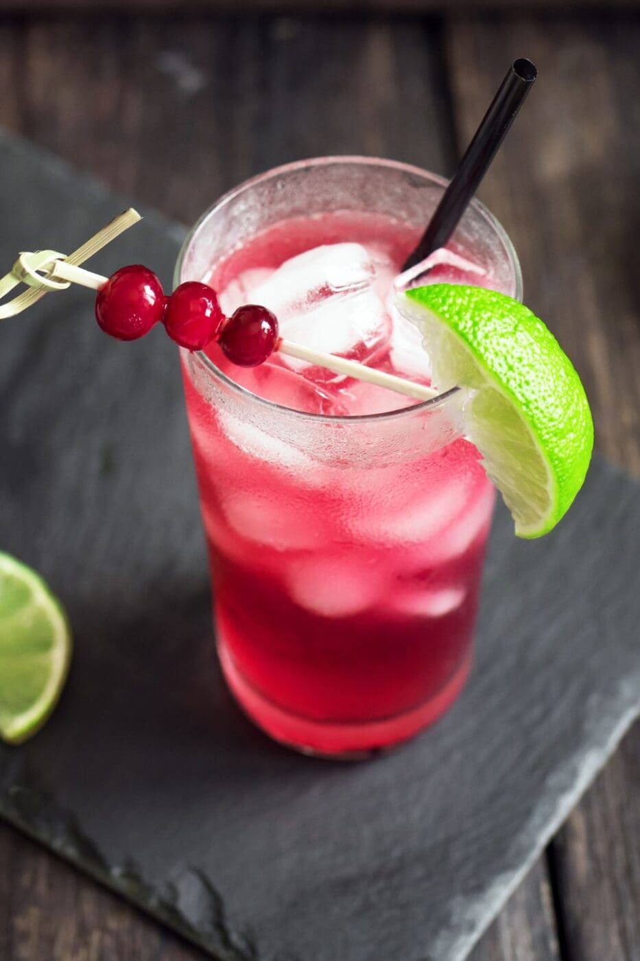 A vibrant Cape Cod cocktail with cranberry juice, vodka, and a fresh lime garnish in a glass.