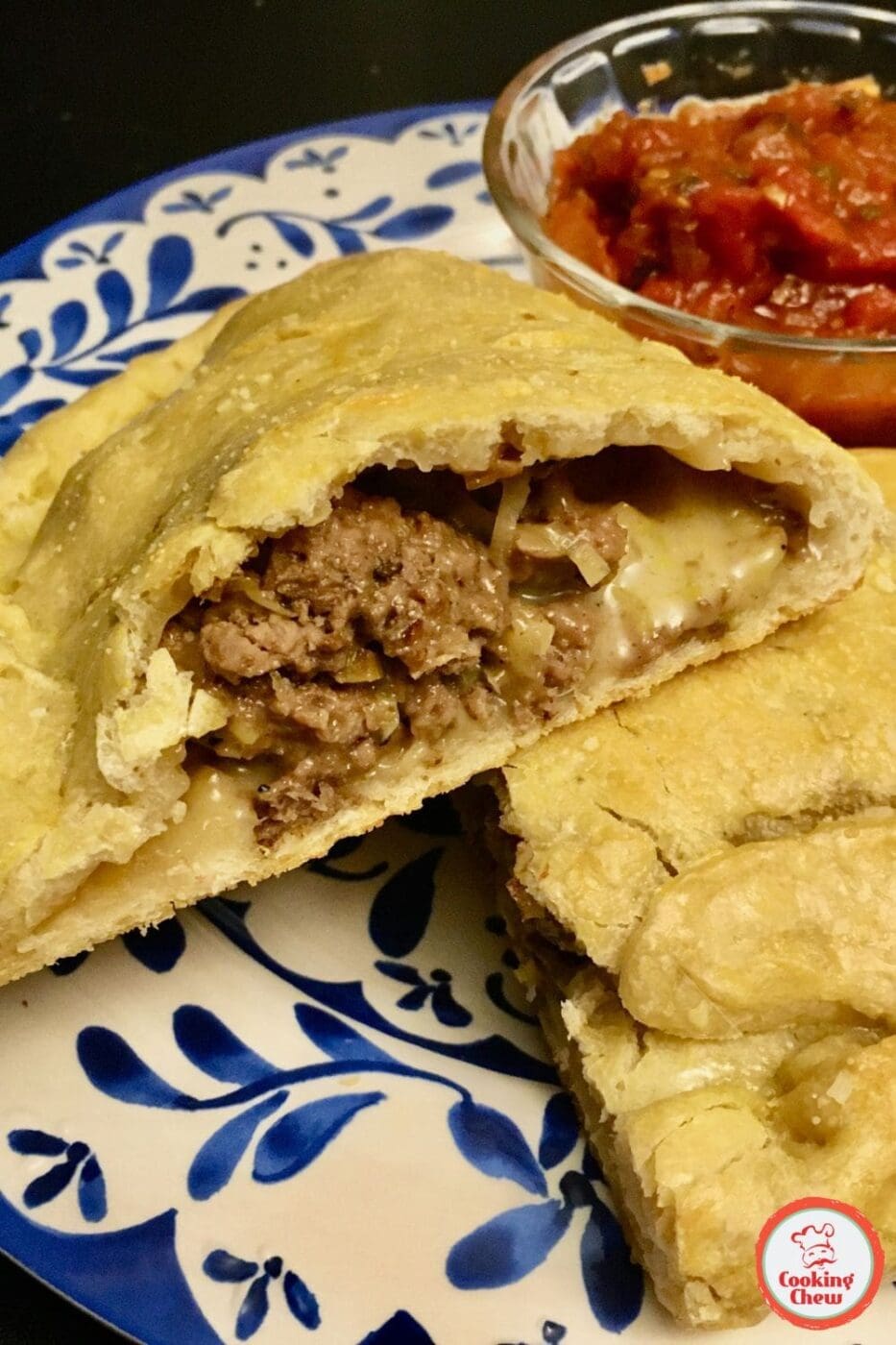 A delicious oven-baked ground beef calzone stuffed with cheese and chunky marinara, freshly baked and sliced.