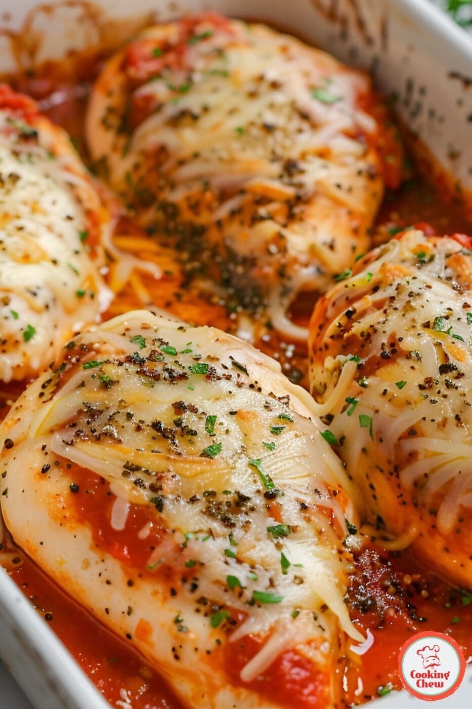 A cheesy marinara chicken bake fresh out of the oven, topped with melted mozzarella and fresh herbs.