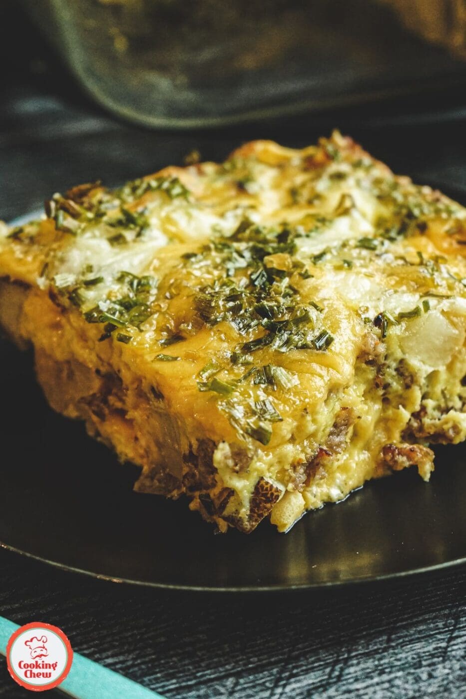 A golden, bubbly sausage and potato casserole with melted cheese in a baking dish.