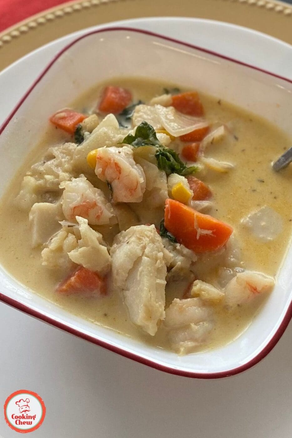 A bowl of rich and creamy seafood chowder filled with chunks of seafood and vegetables.