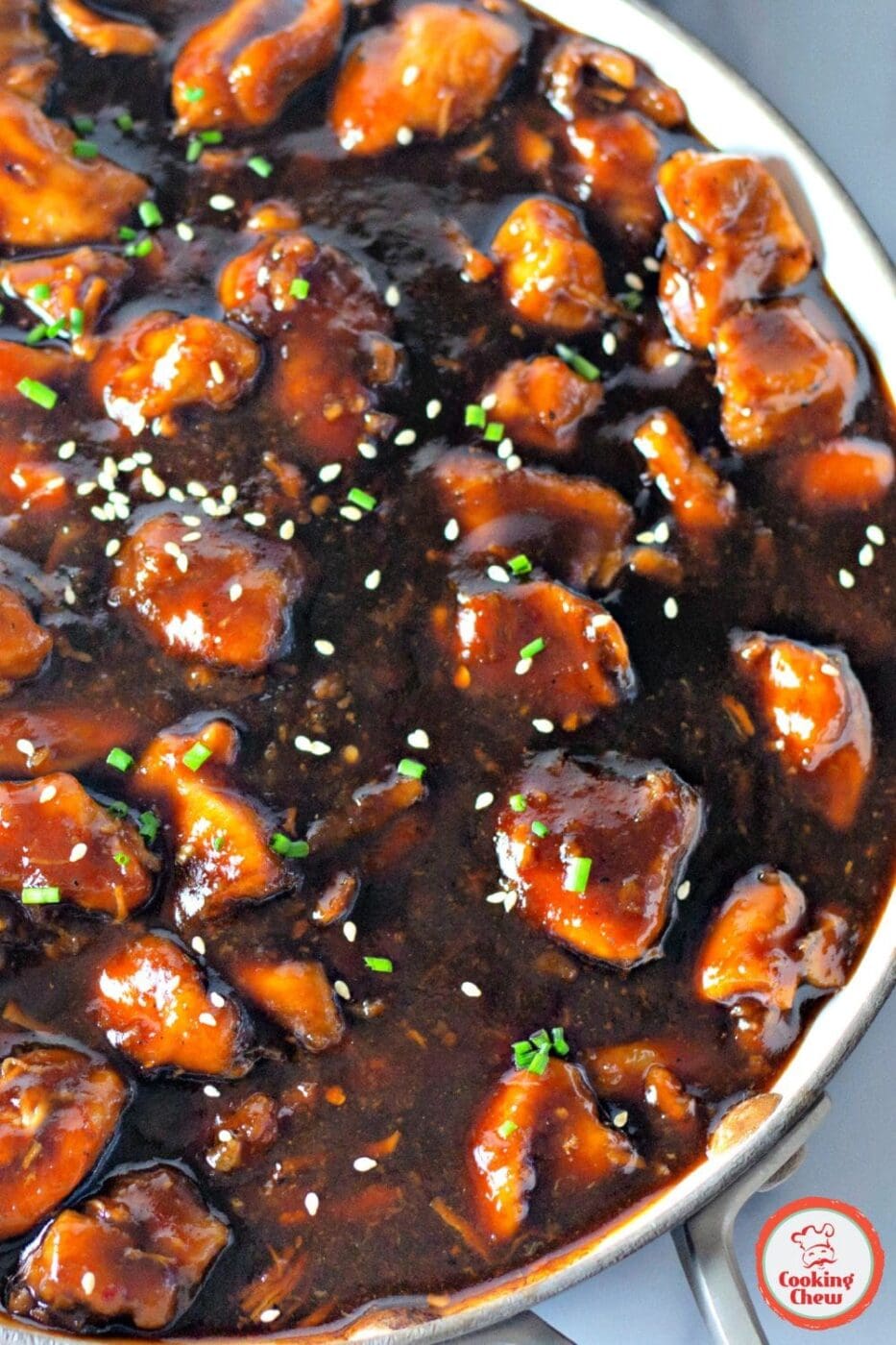 A plate of homemade bourbon chicken coated in a sweet and savory sauce, served with rice.