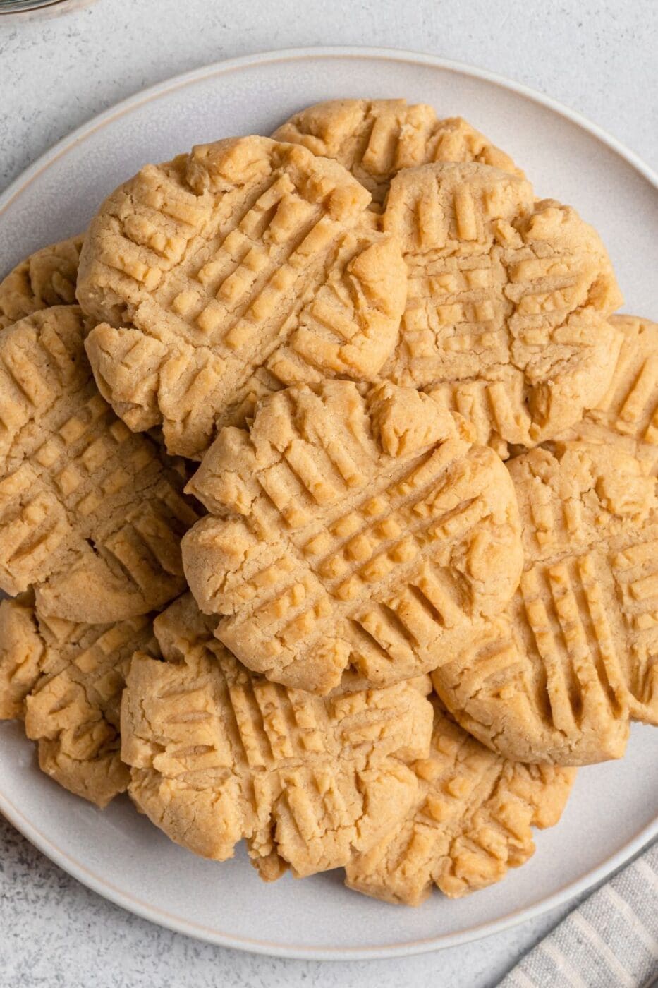 A stack of soft and chewy peanut butter cookies with a classic crisscross pattern.