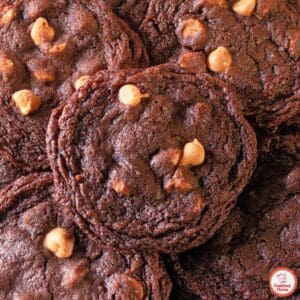 A close-up of thick chocolate cookies with peanut butter chips, fresh from the oven.