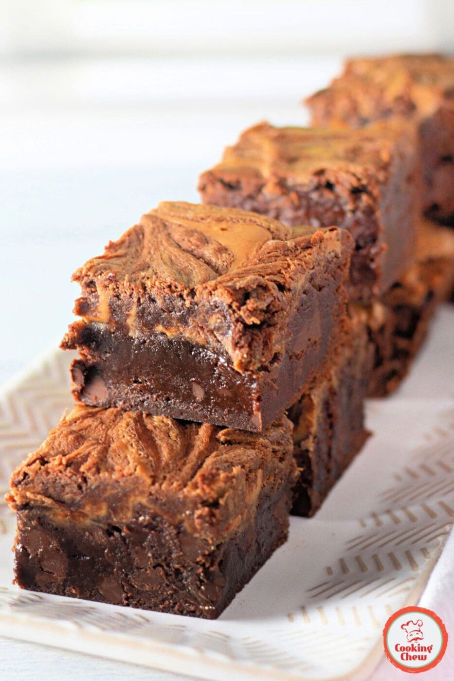 A close-up of rich, fudgy brownies with a beautiful peanut butter swirl on top.