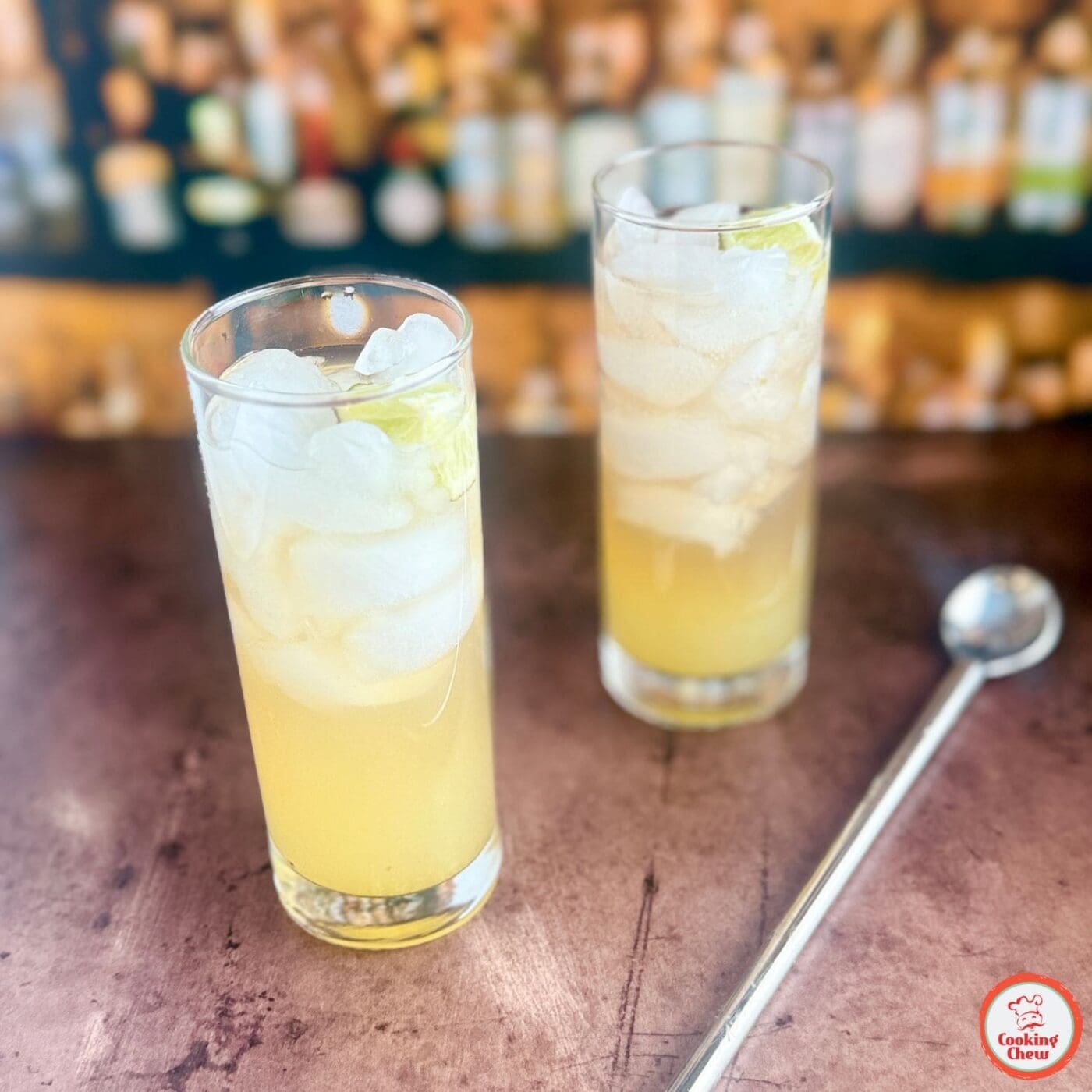 A bartender pouring a jalapeño lime cocktail into a glass.
