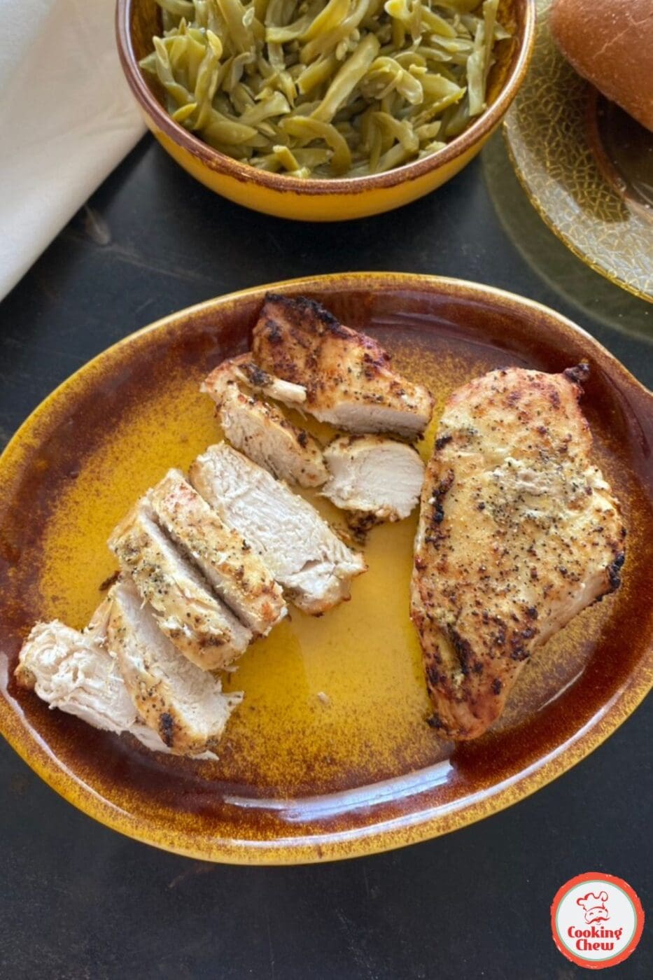 Perfectly seasoned and juicy air fryer chicken breast sliced on a plate, ready to serve.