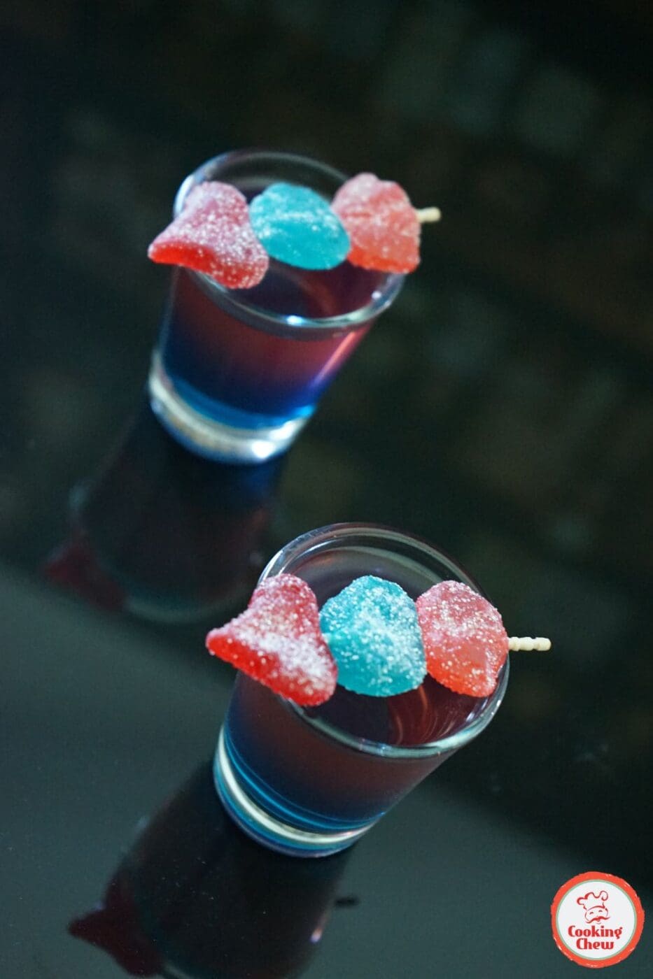 A vibrant, layered Jolly Rancher Shot in a glass, showcasing bright candy-inspired colors.