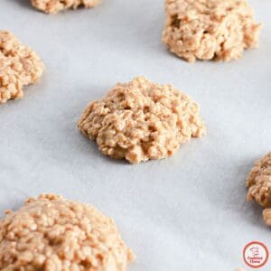 A stack of peanut butter no bake cookies drizzled with melted peanut butter.