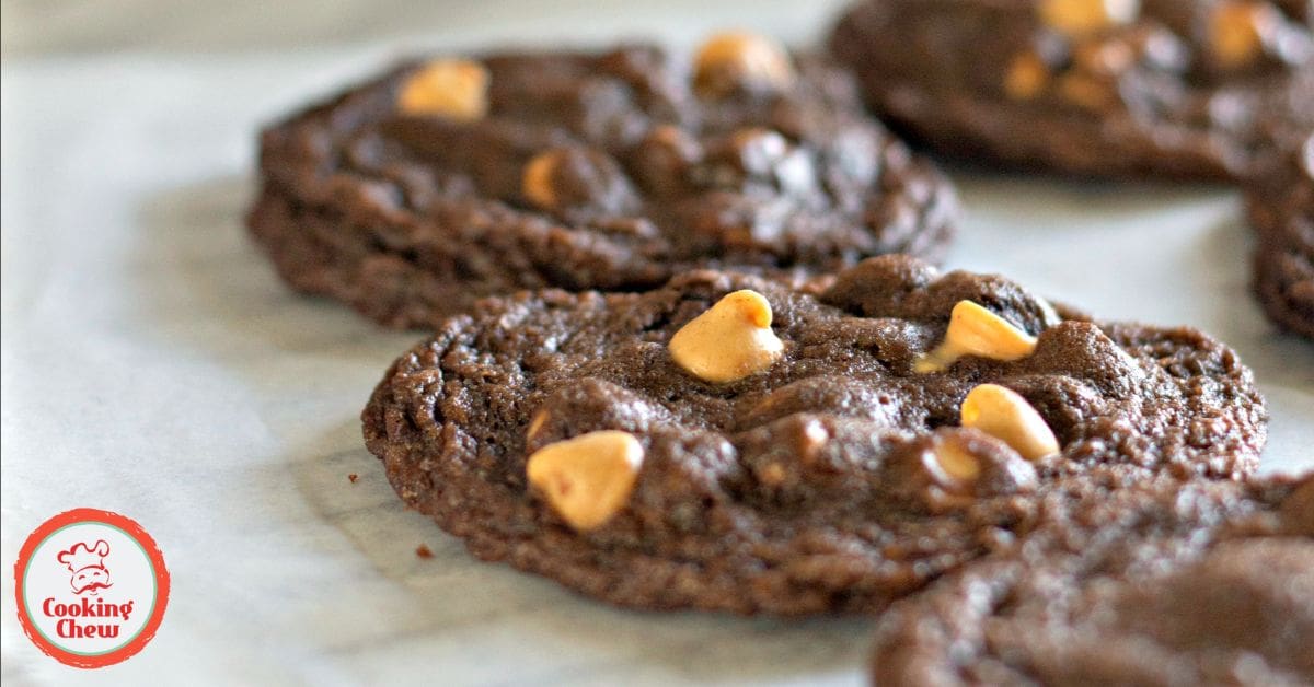 A wire rack with freshly baked chocolate cookies with peanut butter chips, cooling and ready to enjoy.