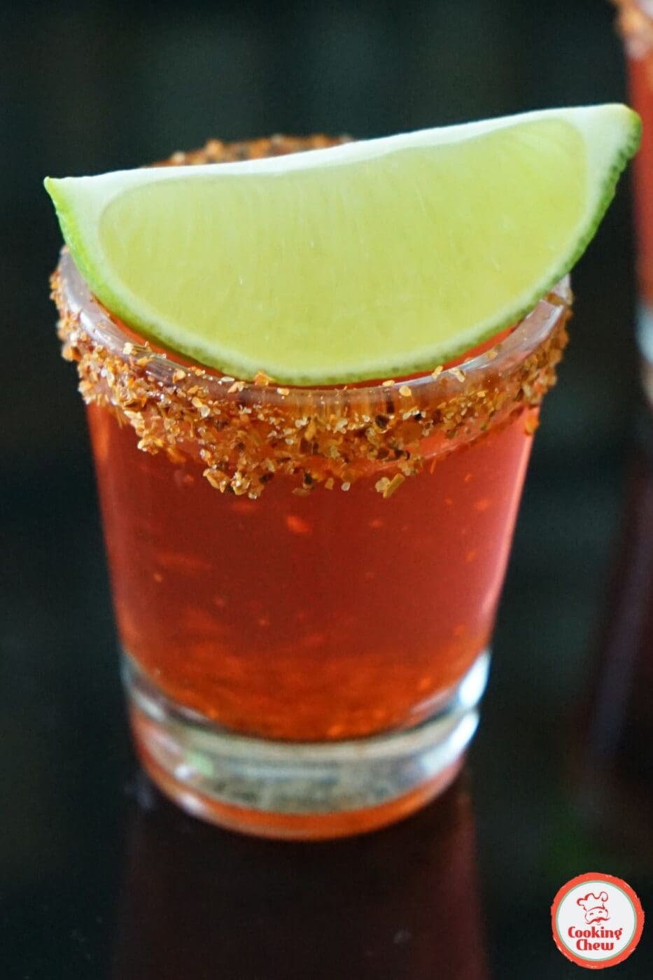 A vibrant Mexican Candy Shot with a chili-lime rim, garnished with fresh fruit.