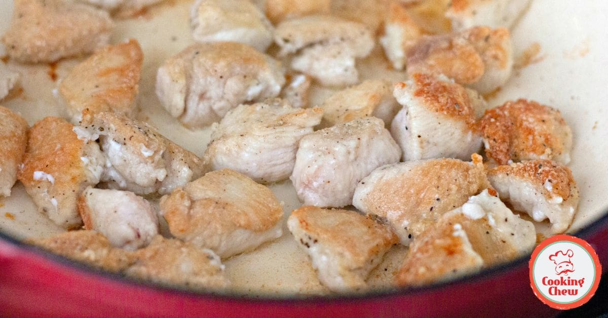 A skillet of bourbon chicken simmering on the stovetop.