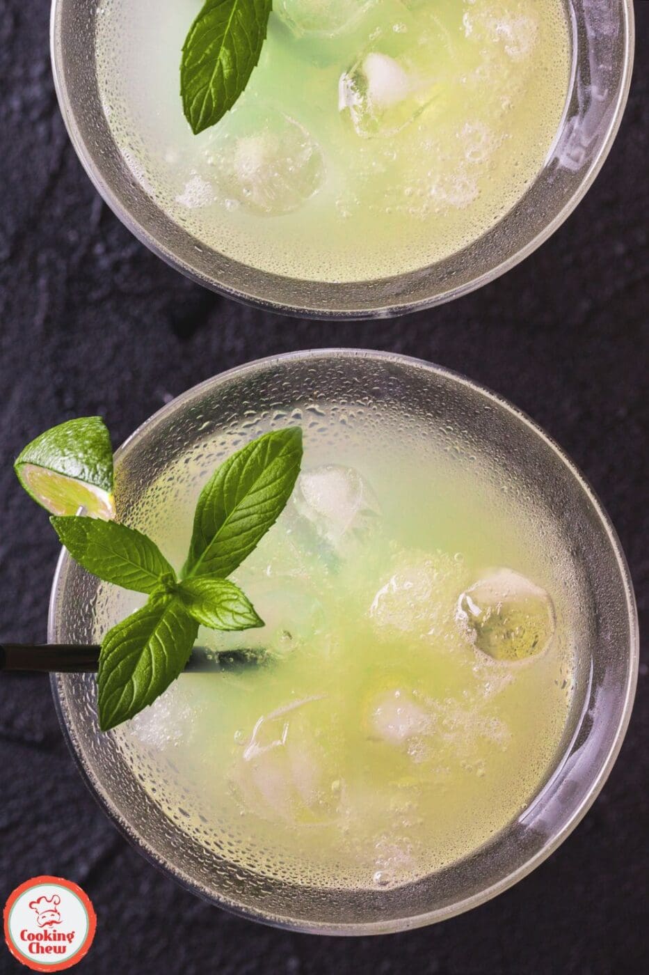 A chilled glass of Mexican Martini garnished with olives and lime.
