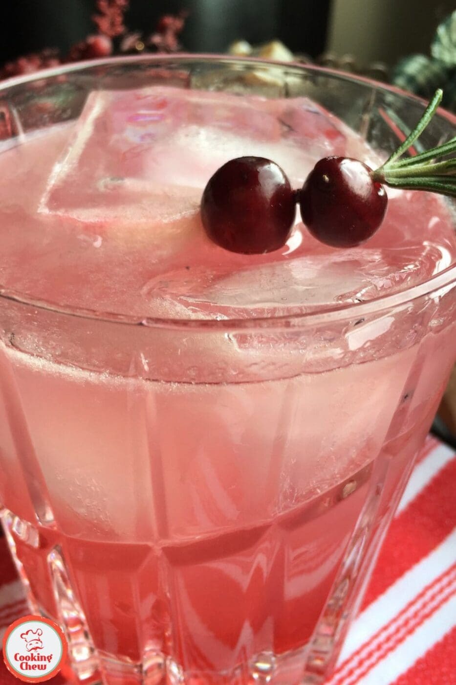 A vibrant Cranberry Margarita in a glass, garnished with fresh rosemary and cranberries.