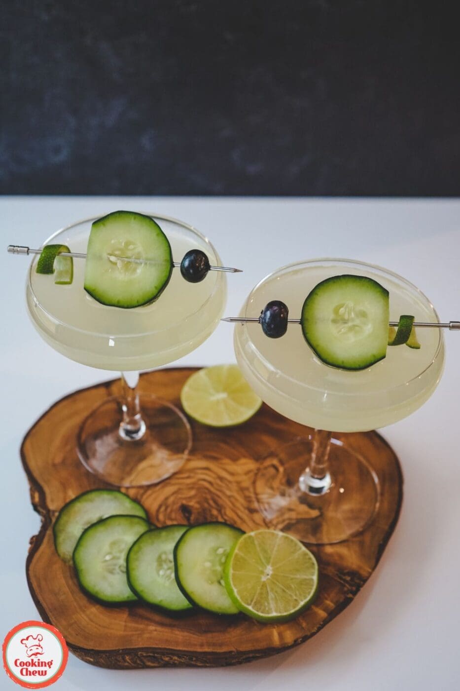 A chilled Cucumber Gimlet in a glass, garnished with fresh cucumber slices and a lime wedge.