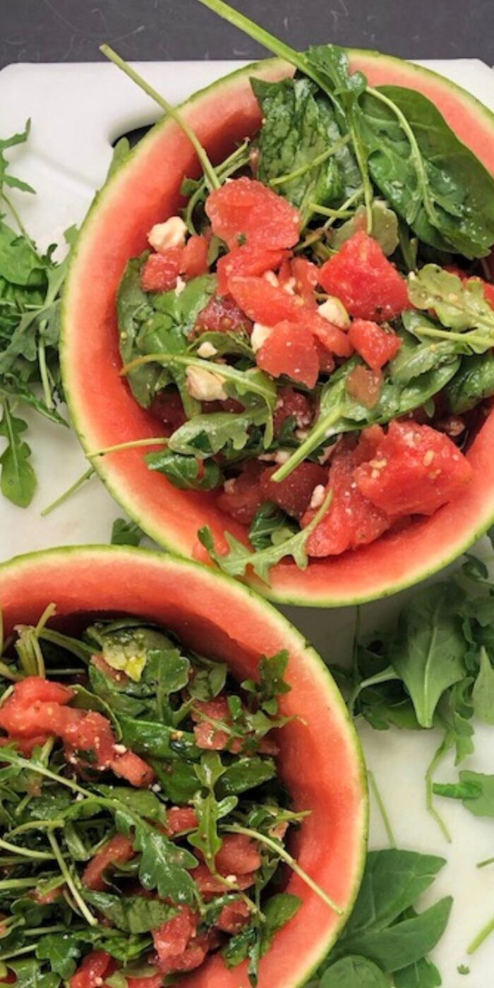 Watermelon and feta salad with mint and arugula served in a carved watermelon bowl, perfect with lemon chicken.