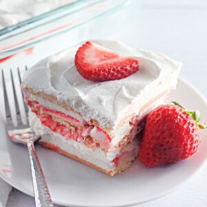 Slice of easy strawberry ice cream cake on a white plate.​
