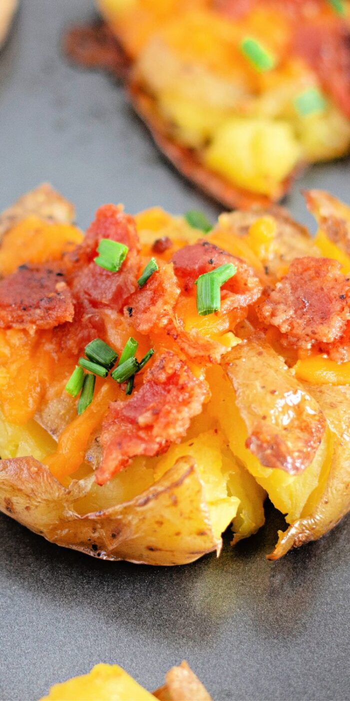 Crispy smashed potatoes topped with cheddar and bacon, oven-roasted for a flavorful, easy side dish.