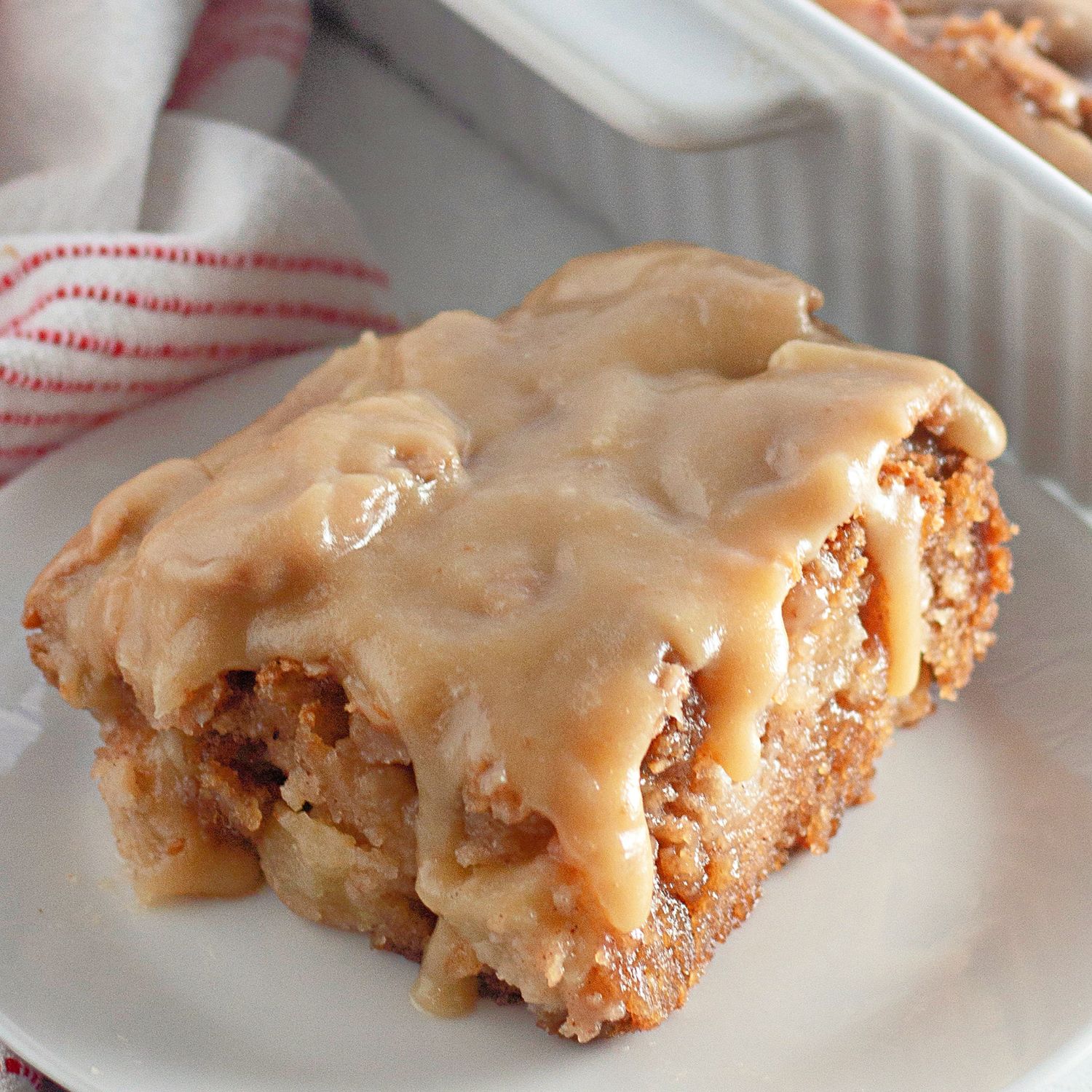 A beautifully presented full apple dapple cake with a shiny caramel glaze.